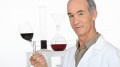 A scientist holding a wine glass in his laboratory